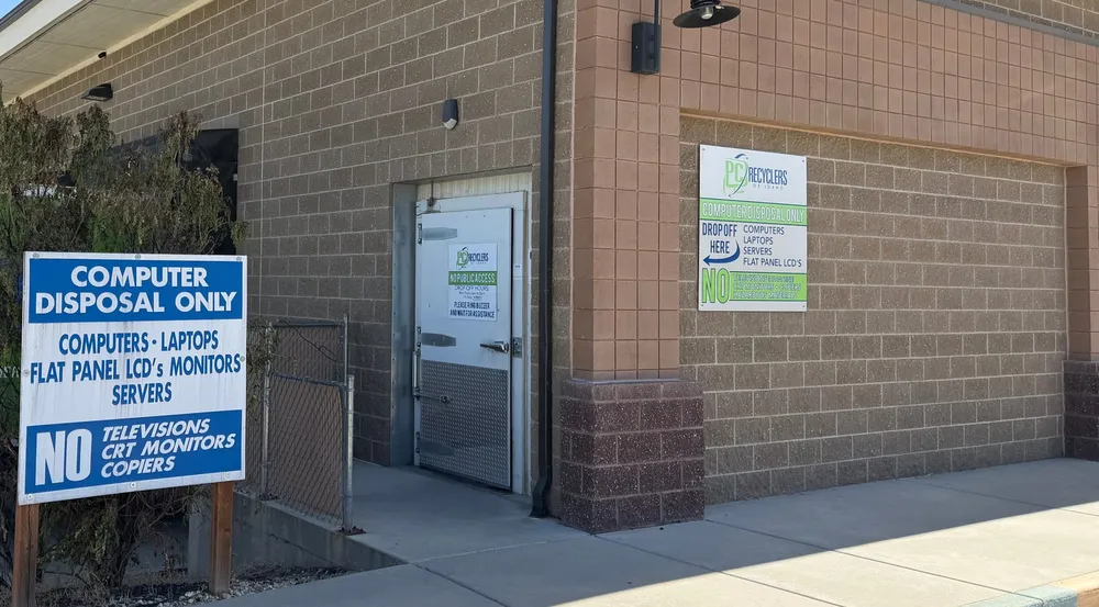 The drop-off door at PC Recyclers of Idaho, signed “Drop Off Here”, with a buzzer to ring for assistance